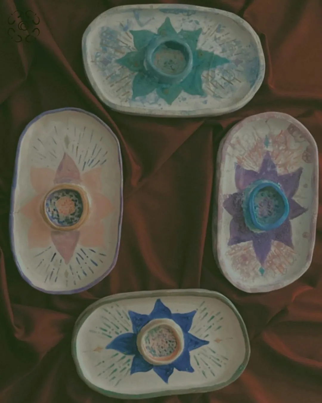 Cuatro platos ovalados pintados con flores y estrellas